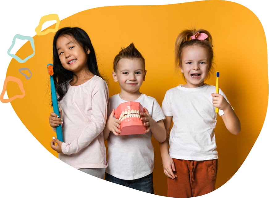 Three smiling kids holding oversized toothbrushes